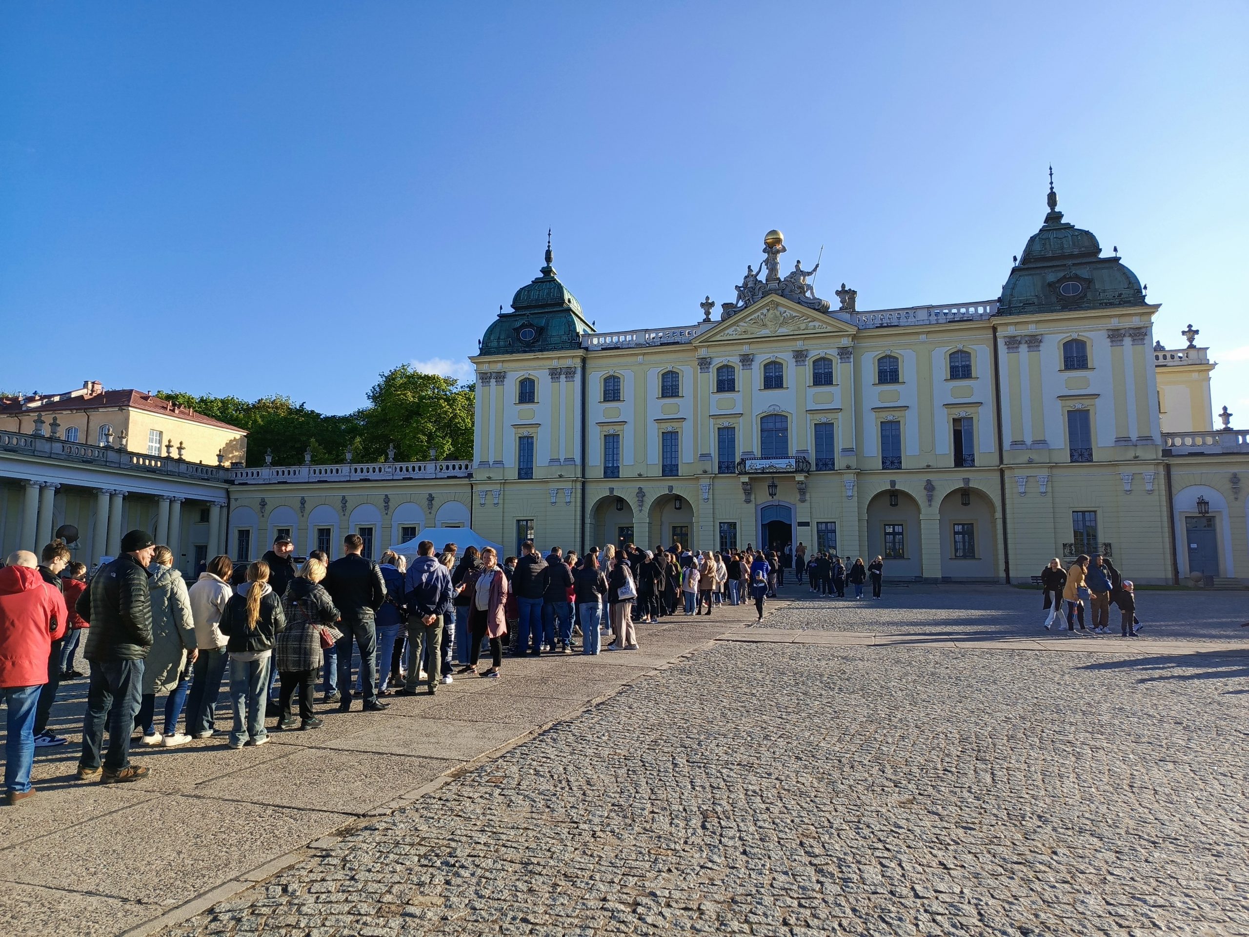 kolejka ludzi rozciągająca się przed pałacem branickich w Białymstoku