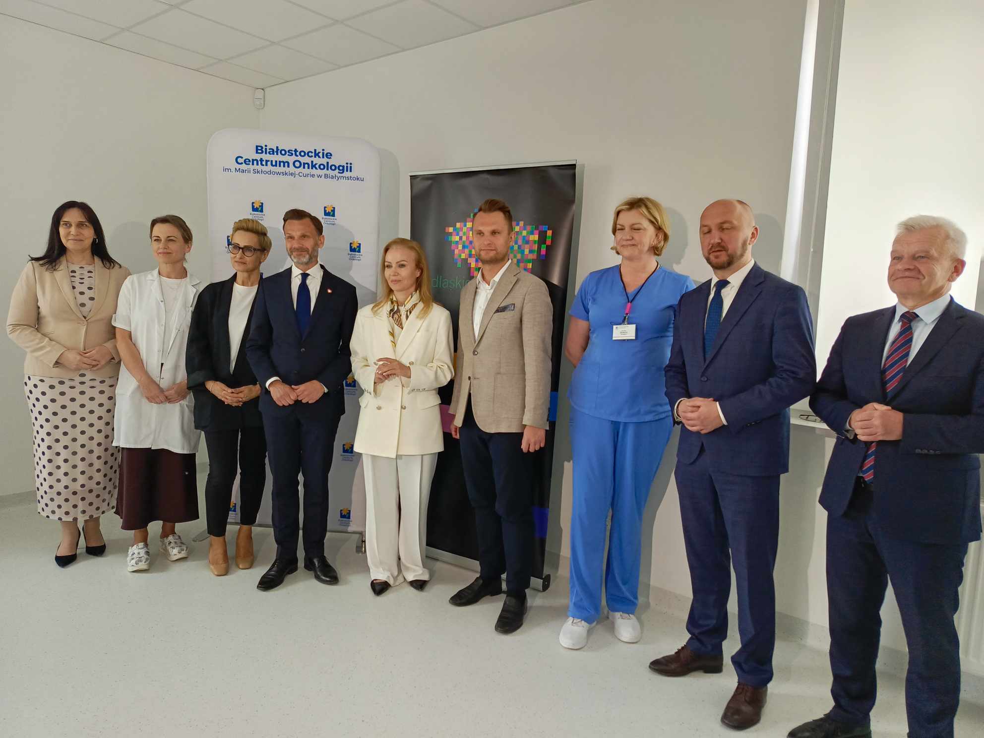 przedstawiciele samorzadu w garniturach i pracownicy BCO stoja na konferencji prasowej przed mikrofonami
