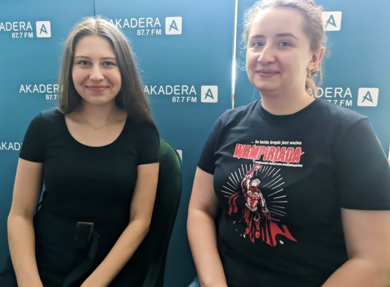 Dwie młode kobiety na ściance firmowej.