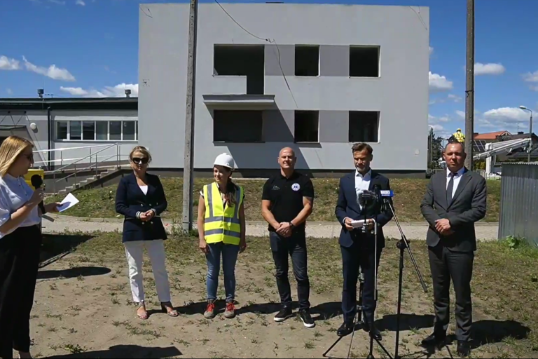 ludzie stoją na tle budowanej dyspozytorni