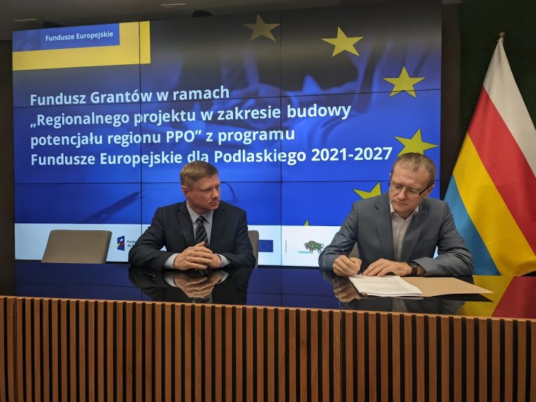 Mężczyźni podpisują dokumenty.