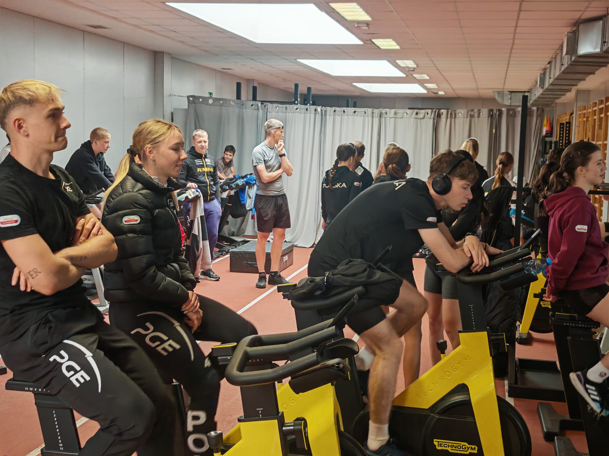 Zawodnicy w short track robią trening na rowerach stacjonarnych