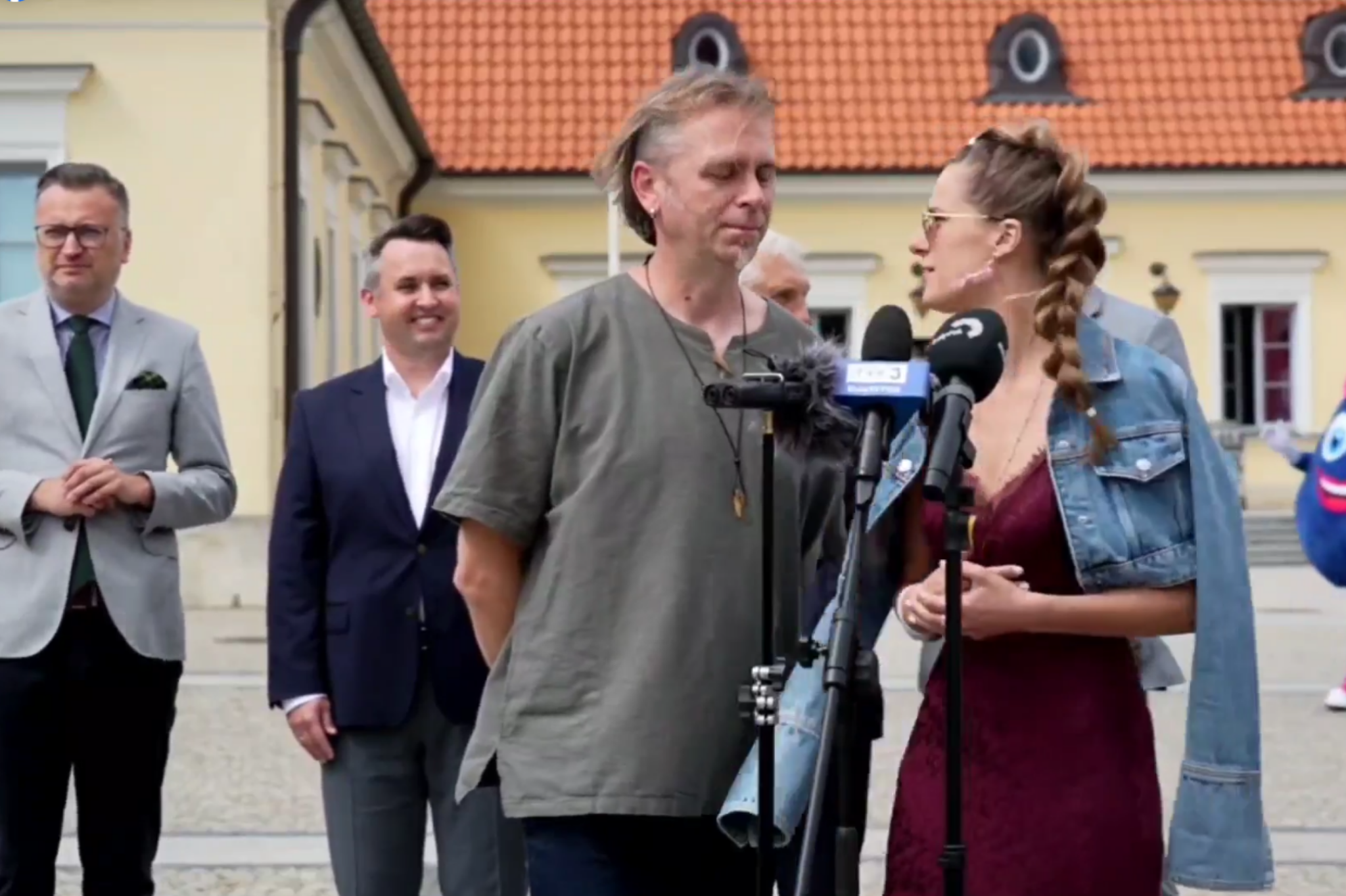 konferencja prasowa na pierwszym planie kobieta i mezczyzna