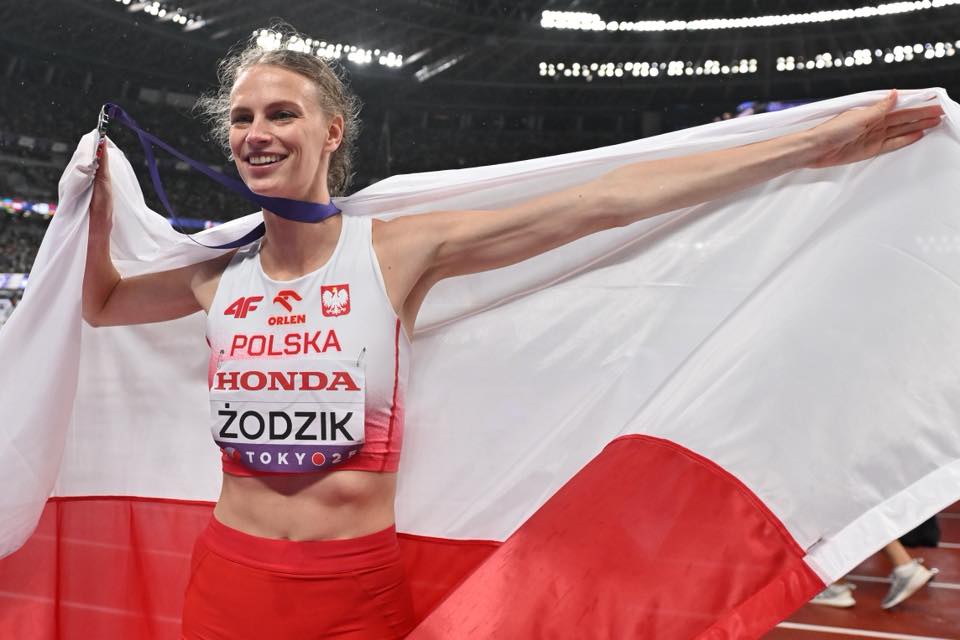 Lekkoatletka z flagą Polski.