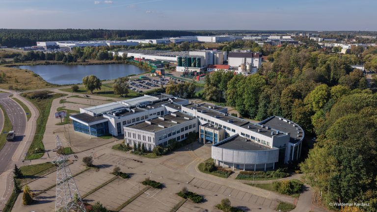 Panorama lotnicza kompleksu budynków po dawnej Wyższej Szkole Administracji Publicznej w Białymstoku przy ul. ks. St. Suchowolca 6, otoczonych parkingami i zielenią. Obiekt wkrótce stanie się nową siedzibą Urzędu Miejskiego.