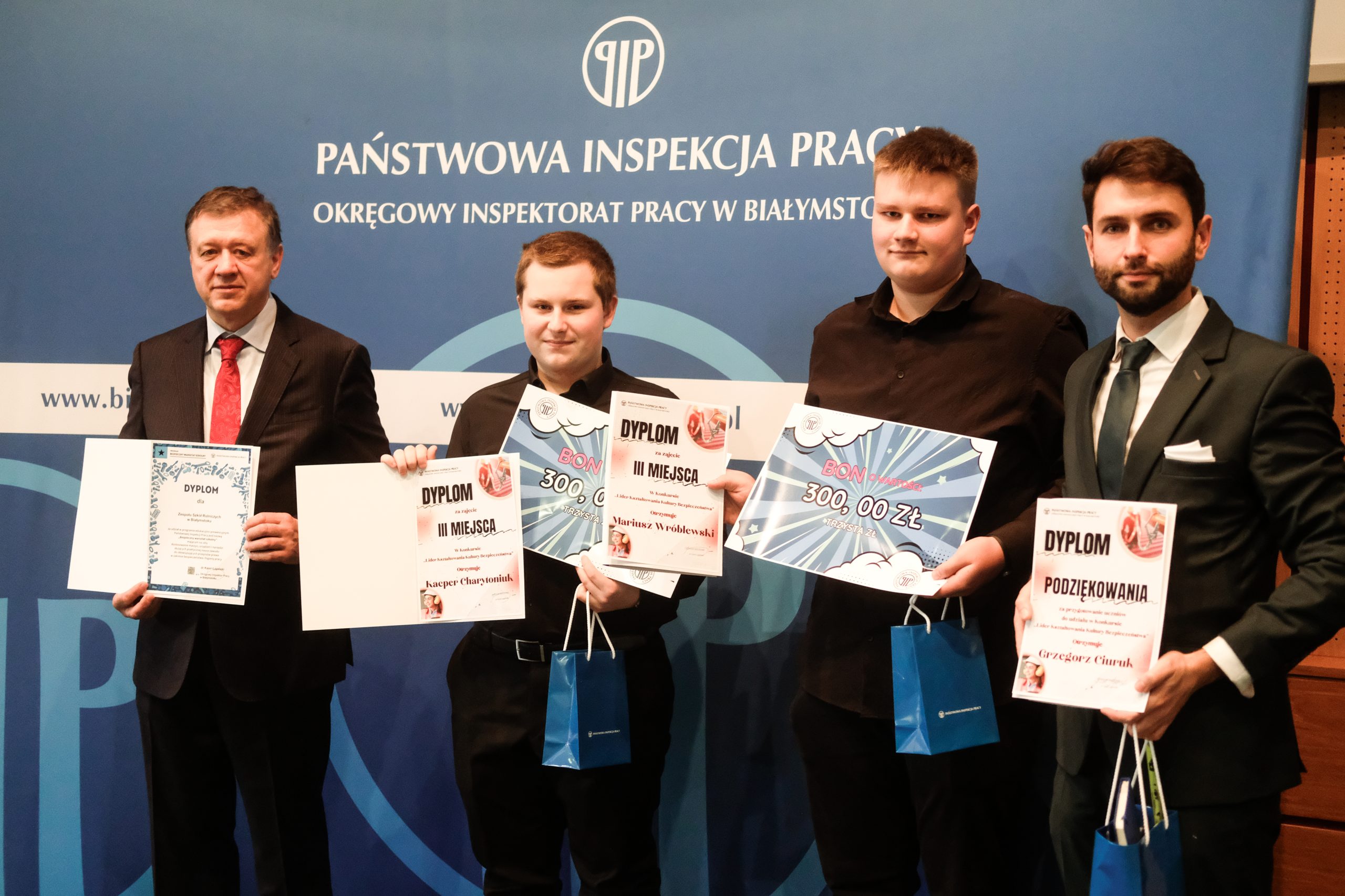 Laureaci konkursów i programów Okręgowego Inspektoratu Pracy w Białymstoku prezentują dyplomy i nagrody podczas uroczystej gali poświęconej bezpieczeństwu pracy.