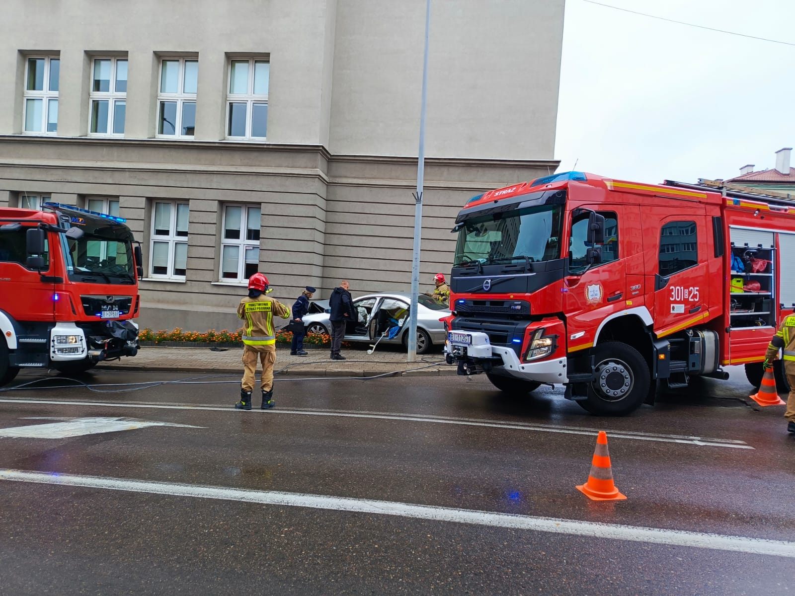 Strażacy z Białegostoku usuwają skutki wypadku, w którym peugeot uderzył w ścianę liceum. Fot. Piotr Jakubiak